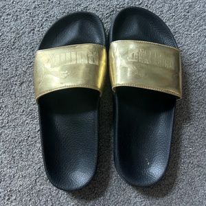Gold and black Puma slides